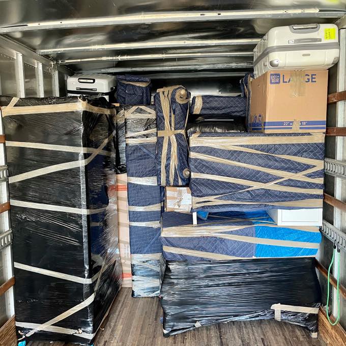 Blanket-wrapped and shrink-wrapped furniture strapped securely inside the truck
