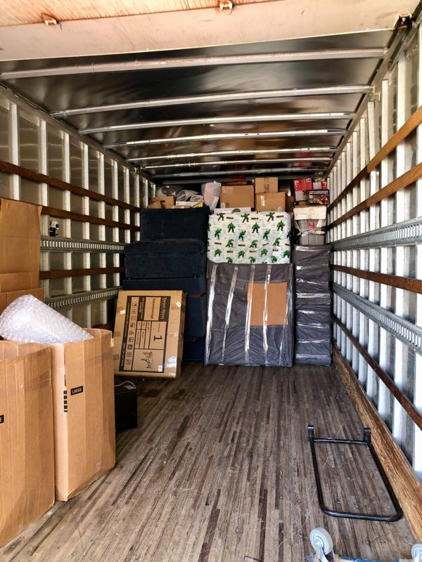 Fully loaded moving truck interior with furniture and boxes neatly secured